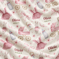 Personalized baby blanket with a watercolor-style print featuring pink dresses, baby carriages, bottles, bunnies, bows, and the text 'Olivia GRACE' on a cream background.