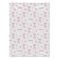 A blanket with a white background featuring a repeating pattern of pink ballet bows, butterflies, and the name 'Isabelle' in pink script.