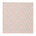 A square personalized baby swaddle blanket with a delicate floral and bird pattern on a light pink background, featuring the name 'AMELIA' printed repeatedly in blue.