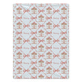 A rectangular fabric item, likely a blanket or towel, featuring a repeating pattern of carousel illustrations, red bows, and the name 'Emery' in cursive on a pale blue background.