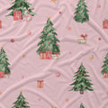 Pink fabric with a watercolor Christmas tree and gift pattern, featuring green trees, red and gold ornaments, and wrapped presents.