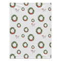 A personalized blanket featuring a repeating pattern of green Christmas wreaths with red bows and the brand name 'Jack Wyatt' printed in red and brown script.