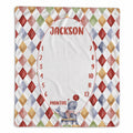 A personalized baby monthly age tracker blanket featuring a colorful harlequin diamond pattern border, a central white oval space for a photo, and red text reading 'JACKSON' and 'MONTHS' with numbers 1 through 12. A small juggling bear illustration is at the bottom.