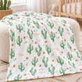 Personalized Peach Cactus Baby Girl Blanket. Soft green cacti, peach flowers, and scattered accents create a cheerful desert garden around a custom name.