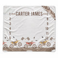 A white personalized blanket featuring a dirt bike race theme, with the name 'CARTER JAMES' printed at the top, numbered positions 1 through 12, and illustrations of dirt bikes along the bottom.