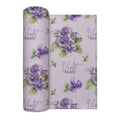 Pale lavender swaddle blanket with purple violet flowers, green leaves, and the name Violet Mae in purple and green lettering.