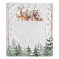A baby milestone blanket with a woodland theme, featuring watercolor-style illustrations of a bear, deer, fox, bird, and pine trees. The center is blank with printed numbers 1 through 12 arranged vertically on both sides.