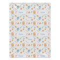 A square fabric item, likely a tea towel or blanket, featuring a festive gingerbread house pattern on a white background. The design includes the name 'Emma' in blue, decorated with blue mugs, brown gingerbread houses, and small green leaves.