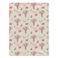 Cream blanket with peach-pink carnation bouquets, green leaves, and the name Amelia Rose in coral and green lettering.