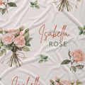 Ivory fabric with peach rose bouquets, scattered green leaves, and the name Isabella Rose in coral and green lettering.