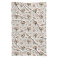 Ivory swaddle blanket with peach rose bouquets, scattered green leaves, and the name Isabella Rose in coral and green lettering.