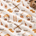 A close-up of a white fabric with a repeating watercolor-style print of rustic farm motifs, including windmills, baskets, huts, axes, brushes, and the text 'Knox William'.