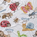 A close-up of a white fabric printed with a whimsical insect and nature pattern, including ladybugs, a butterfly, bees, a spider, a snail, a green caterpillar, and the personalized text 'Daisy MAE' in blue script.