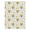 Ivory blanket with yellow daffodil clusters, scattered green leaves, and the name Clara Mae in gold and sage green lettering.