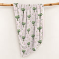 Pale blush swaddle blanket with white lily of the valley bouquets, green leaves, and the name Lillian Grace in rose and green.