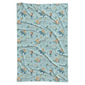 A rectangular baby blanket with a repeating mermaid and dolphin pattern on a light blue background, featuring the name 'Anna' printed in gold script.