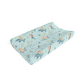 A contoured baby changing pad cover featuring a light blue background with a whimsical mermaid and sea creature pattern, shown on a clean white background.