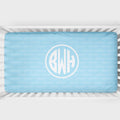 A light blue baby crib bedding set featuring a duvet cover and matching pillowcase with a repeating monogram pattern of 'BECKETT' and a large circular monogram 'BWH' in the center.