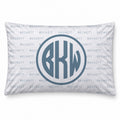 A personalized pillowcase featuring a monogrammed circular design with the letters 'BKW' in a slate blue-gray color. The background of the pillow is white with a repeating light blue 'BECKETT' brand watermark pattern.