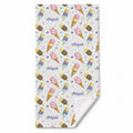 A personalized beach towel with a repeating ice cream cone and popsicle print, plus the name 'Abigail' repeated in purple script. The product is shown flat against a white background with one corner folded over to reveal the white reverse side.