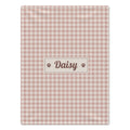 A rectangular pink and white gingham dog blanket with a central cream label that reads 'Daisy' in brown script, flanked by two small paw prints, shown on a plain white background.