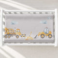 A changing pad cover featuring a construction theme, including a yellow cement mixer truck, a yellow front loader, a bulldozer, and small blue clouds.