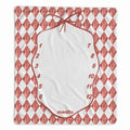 A square baby milestone blanket featuring a red and white harlequin diamond pattern border, a central white oval space outlined in red with the words 'months' and numbers 1 through 12, and a red bow illustration at the top.