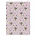 Mauve-pink blanket with lavender aster bouquets, yellow flower centers, green leaves, and the name Evelyn Claire.