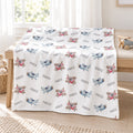 Personalized Airplane Baby Blanket. Watercolor airplanes surround a custom name in soft blue, grey, and pink tones on a white background.