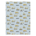 A personalized baby blanket with a light blue background, featuring a repeating pattern of yellow construction vehicles and the name 'DANIEL' printed in black.
