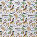 A close-up of a white fabric surface printed with a repeating pirate-themed pattern. The design includes palm trees on small islands, treasure maps, ship's wheels, swords, bottles, and a recurring figure labeled 'Archer JAMES'.