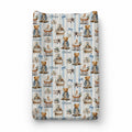 A personalized changing pad cover featuring a repeating vintage-style print with teddy bears in prams, blue bows, small airplanes, and the name 'Oliver' on a light blue and white striped background.