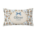 A personalized pillowcase featuring a blue and cream teddy bear pattern, with a central cream label containing the names 'Oliver' and 'JAMES' and a blue bow illustration.