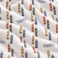 A close-up of a white plush fabric with an all-over print of colorful crayons and the name CASEY repeated in dark blue text.