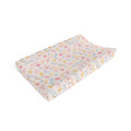 A personalized baby changing pad with a pastel floral and bird pattern on a cream background, featuring the name 'AMELIA' printed in blue. The pad is shown at an angle on a clean white background.