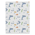 Personalized Shark Baby Blanket. Friendly watercolor sharks and colorful little sea details surround a custom name on a white background.