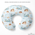 Personalized U-shaped nursing pillow cover featuring a light blue background with a repeating pattern of brown mountains, blue airplanes, clouds, and the text 'COLTON joseph'. The product is displayed on a clean white background with promotional text at the top and the brand logo 'CAIDEN DESIGNS' at the bottom right.