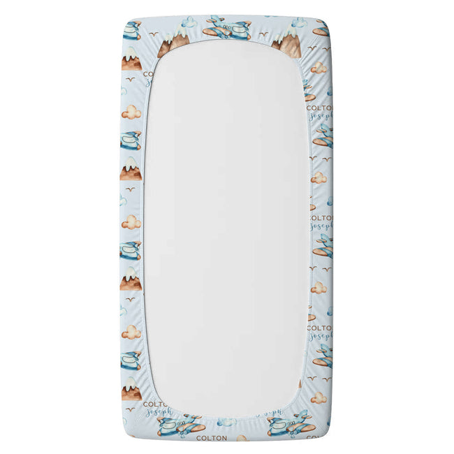 A twin fitted sheet an elasticized border featuring a light blue background and a repeating pattern of brown teddy bears, blue shoes, and the brand name 'COLTON'.
