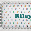 Personalized baby crib bedding set featuring a white fitted sheet and matching pillowcase with colorful alphabet letters, animal illustrations, and the name 'Riley' in large teal text.