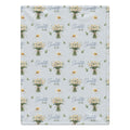 Personalized pale blue blanket with white daisy bouquets, green leaves, and the name Charlotte Mae in blue and green lettering.