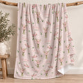 Blush pink blanket with pink gladiolus bouquets, green leaves, and the name Audrey Jane in coral script and green lettering.