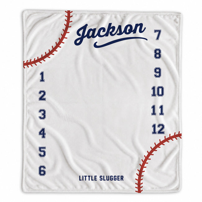 Personalized baseball baby milestone blanket with name, months 1–12, red baseball stitching, and Little Slugger design