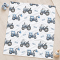 Personalized Blue Tractor Baby Boy Blanket. Blue tractors bring a playful countryside touch to a custom name on a white background.
