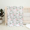Blush Rose Garden personalized baby blanket with pink roses and sage leaves, draped over a natural wood crib.