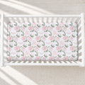 Overhead view of Blush Rose Garden personalized crib sheet with pink roses, sage leaves, and the name Elizabeth Rose in a white crib.