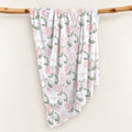 Blush Rose Garden swaddle personalized with Elizabeth Rose, featuring pink roses and sage leaves, draped over a wooden branch.
