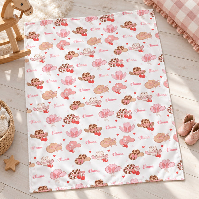 Personalized Cowgirl Hat Baby Girl Blanket. Pink cowgirl hats and sweet bows bring a little western charm to a custom name.