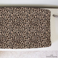 A baby changing pads cover featuring a classic leopard print pattern in beige, brown, and black. It is laid flat on a white surface with a textured white rug underneath.