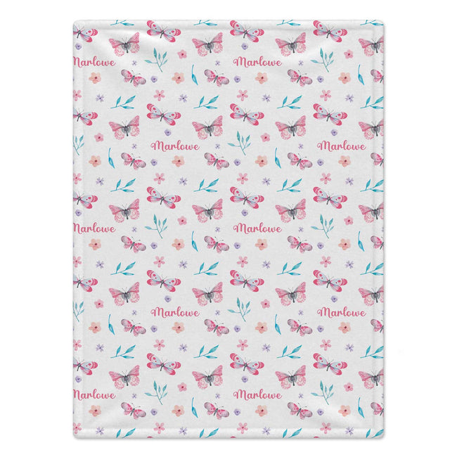 Personalized Pink and Aqua Butterfly Baby Girl Blanket. Pink butterflies, aqua leaves, and delicate flowers surround a custom name on a bright white background.