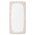 A personalized twin fitted sheet featuring a delicate pastel floral border pattern in pink, yellow, blue, and green on a light cream background.